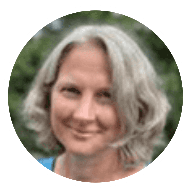 Smiling woman with gray hair outdoors.