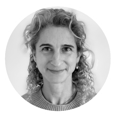 Black and white portrait of a smiling woman with curly hair.